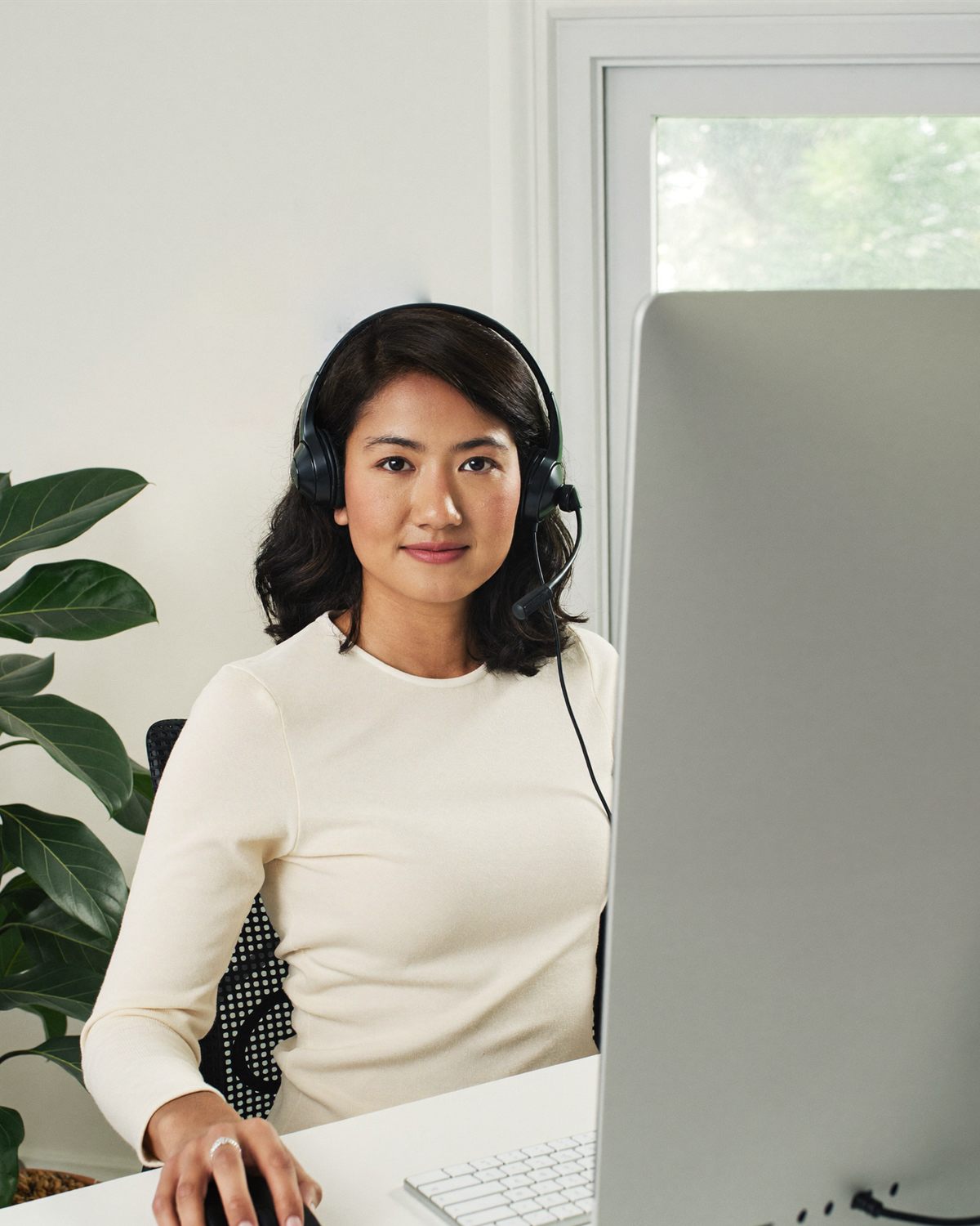 A medical admin assistant VA in a headset working at her computer
