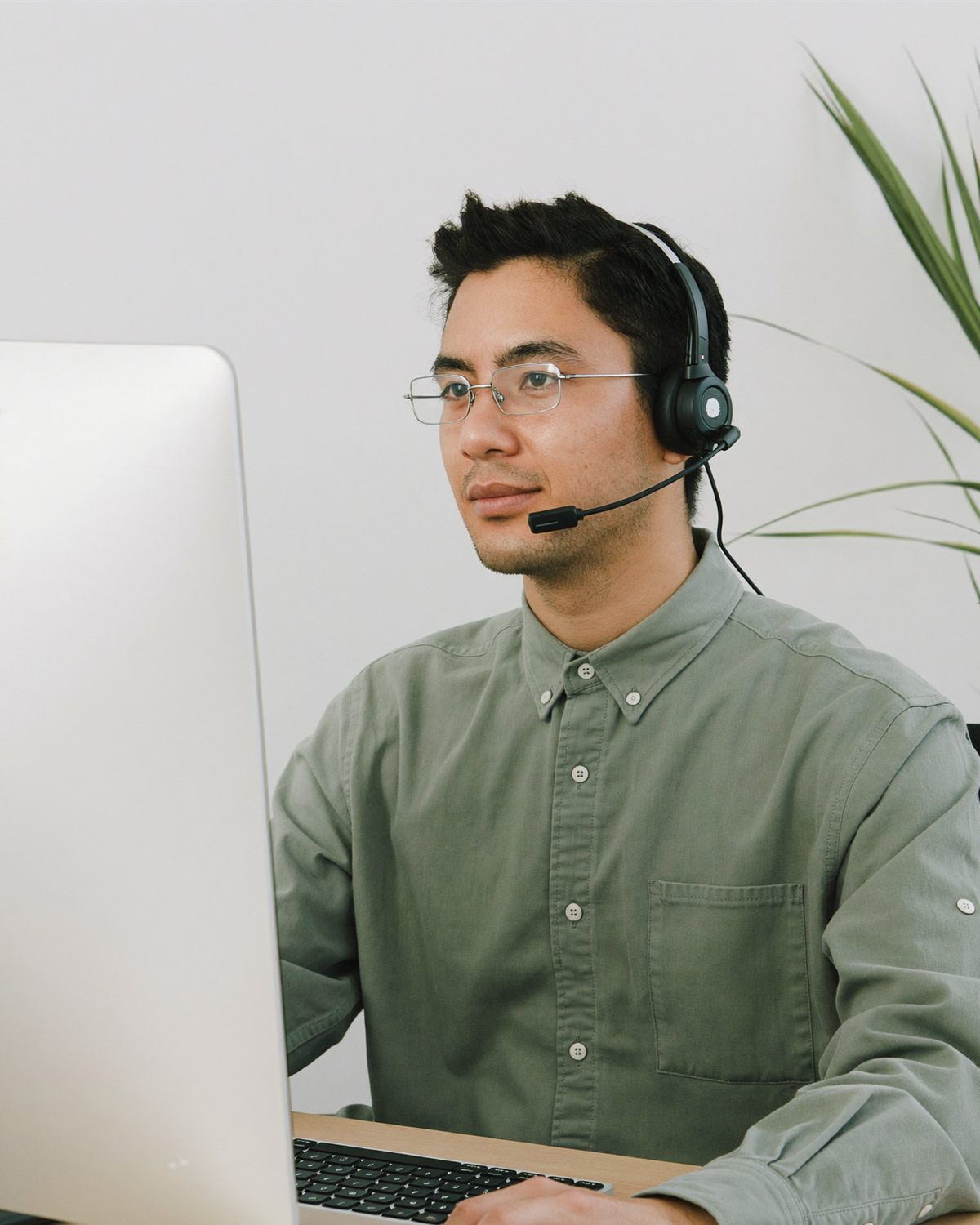A medical billing VA in glasses and a headset working at his computer