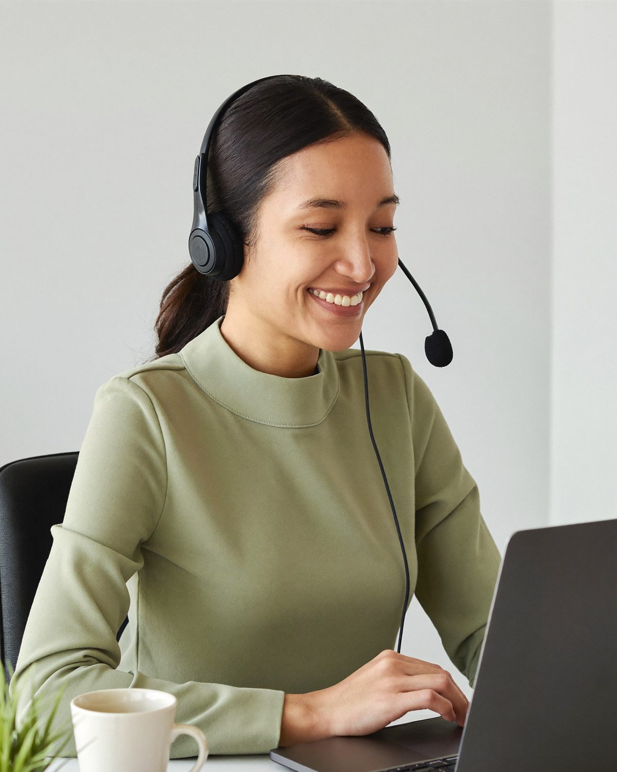 A medical receptionist VA in a headset smiling on a patient call