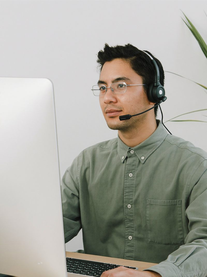 A medical billing VA in glasses and a headset working at his computer